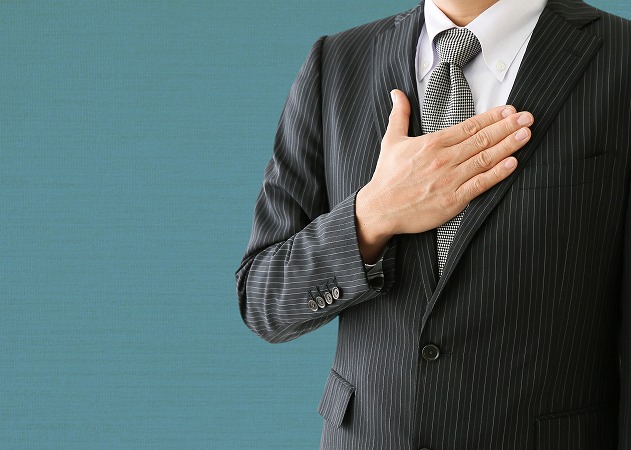 胸に手を当てる男性・スーツ